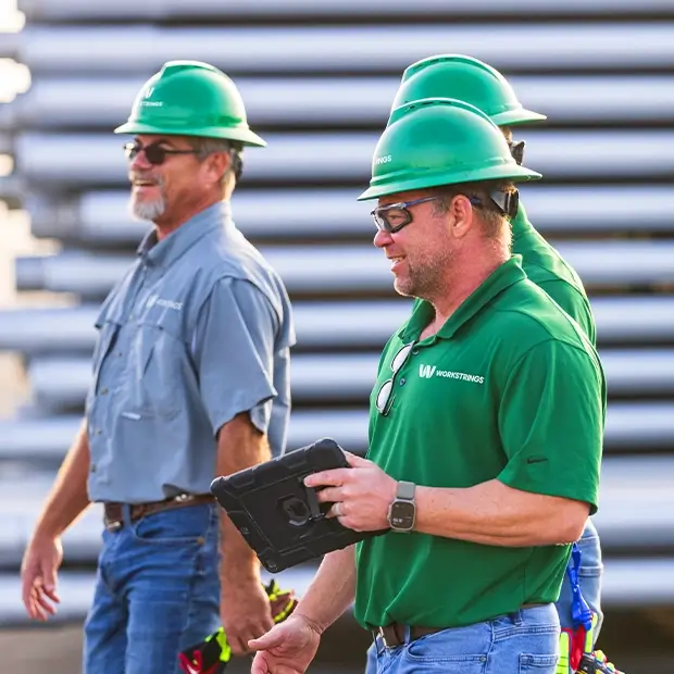 Three Workstrings employees walking together while reviewing inventory