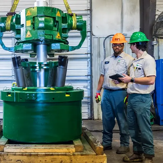 Two Workstrings workers standing next to a FASTR® system on a crate discussing quality checks