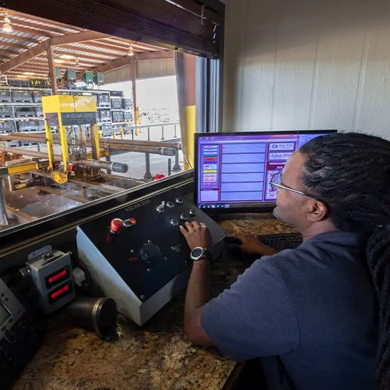 A Workstrings worker operating machinery in a warehouse from the control room