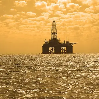 A far off oil rig at silhouetted against the sunset