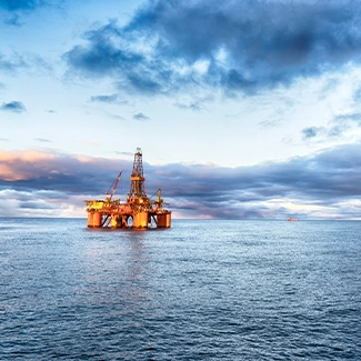 An oil rig lit up at twilight in the Gulf of Mexico
