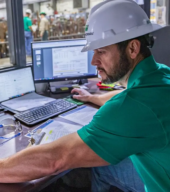 A Workstrings engineer looking over data across multiple monitors