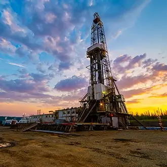 An oil derrick at sunset