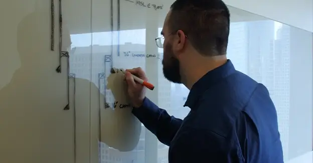 A Workstrings engineer drawing out string design spec on a whiteboard