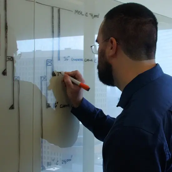 A Workstrings engineer drawing out string design spec on a whiteboard