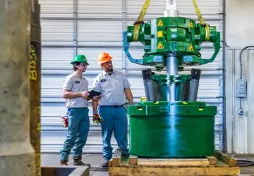 Two Workstrings workers looking at a FASTR® system on a wooden crate