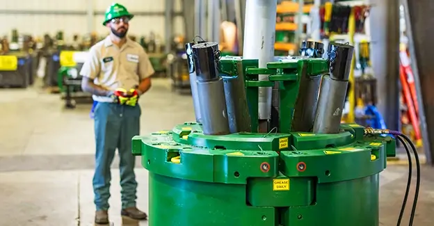 A Workstrings worker in a green helmet looking at the FASTR System