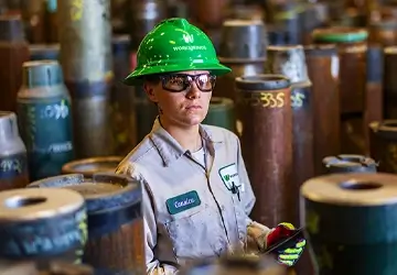 A female Workstrings worker taking inventory of drill pipes